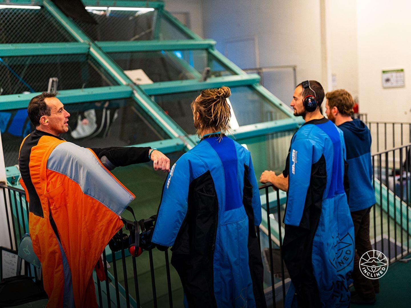 Group in wingsuits near tunnel entrance, highlighting safe, accessible flying for all experience levels.
